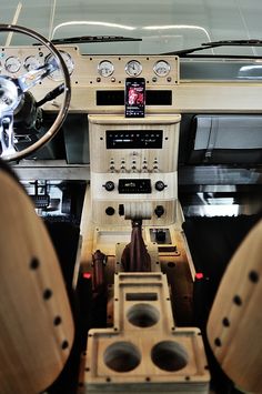 the interior of an old car with wood trims and gauges on it's dash board