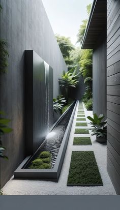 an outdoor garden with plants and water features on the walls, along with concrete walkways