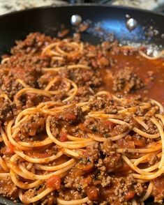 a skillet filled with spaghetti and meat sauce