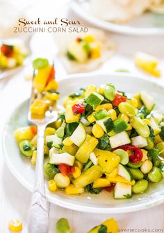 a white plate topped with a salad covered in veggies next to silverware