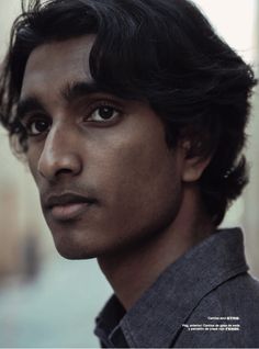 a close up of a person wearing a shirt and looking off to the side with a serious look on his face