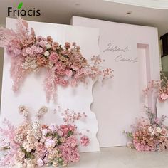 pink flowers are on display in front of a white wall with the words friacts written on it