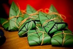 some green cookies wrapped in twine and tied with string on top of a wooden table