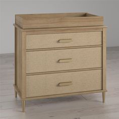 a wooden dresser sitting on top of a hard wood floor next to a white wall