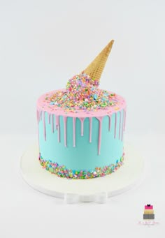 a birthday cake decorated with sprinkles and an ice cream cone on top