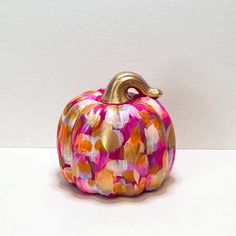 a colorful painted pumpkin sitting on top of a table