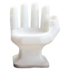 a white plastic chair with four fingers sticking out of it's back end, against a white background