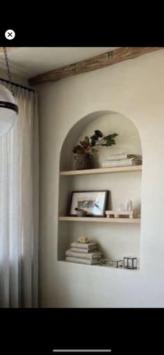 a shelf with books on it next to a window