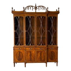 an antique wooden china cabinet with glass doors and carvings on the front, side panels