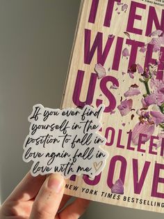 a person holding up a book with writing on it and flowers in the cover,