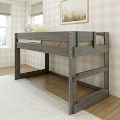 a wooden bunk bed sitting on top of a hard wood floor next to a window