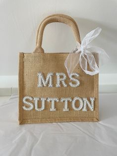 a bag with the words mrs sutton on it is sitting on a white surface