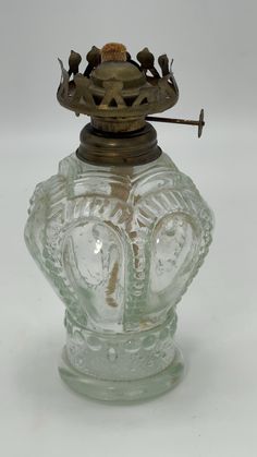 an antique glass vase with a crown on top