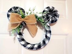 a black and white wreath with a bow on it