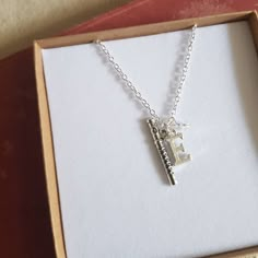 a necklace in a box with the letter e on it