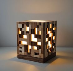 a wooden block with lights in it on a table next to a gray wall and floor