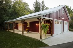 a red and white garage sitting in the middle of a lush green field