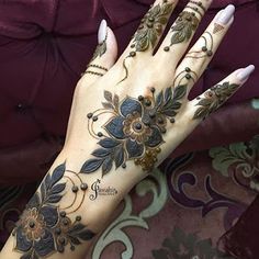 a woman's hand is decorated with hennap and floral designs on it