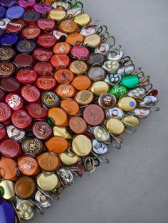 a pile of different colored bottle caps and keychains on top of each other