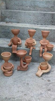 a group of clay pots sitting on top of cement steps next to eachother