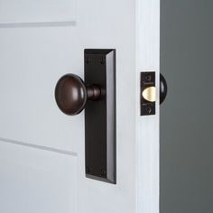 an open door with a black handle on it and a light at the end of the door