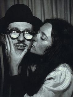 a man and woman kissing each other while wearing glasses