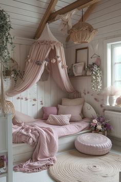 a bedroom with pink bedding and pillows on the floor next to a large window