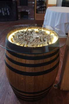 a wooden barrel with rocks in it sitting on the floor next to a white table cloth