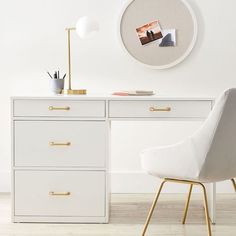 a white desk with two chairs next to it and a clock on the wall above it