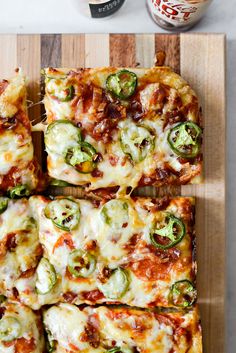 several slices of pizza sitting on top of a cutting board next to ketchup