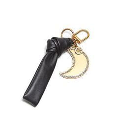 a black leather keychain with a gold moon and crescent charm hanging from it's side