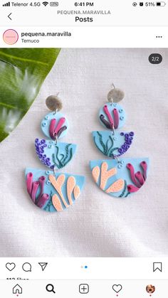 the earrings are made from polymer and have colorful flowers on them, as well as leaves