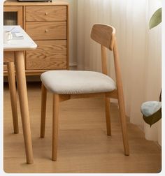 a wooden chair sitting next to a white table