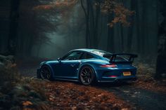 a blue sports car parked in the middle of a wooded area with trees and leaves