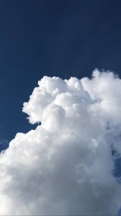 the plane is flying high in the sky with some clouds behind it and an airplane on the far side