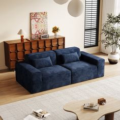 a living room with a blue couch and coffee table in the middle, surrounded by white rugs