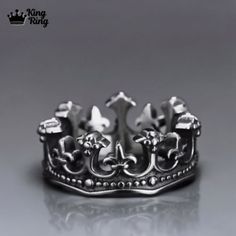 a silver crown ring sitting on top of a table