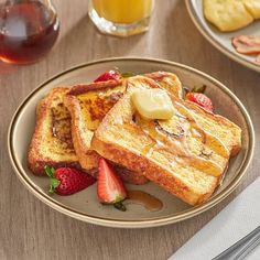 a white plate topped with french toast and fruit next to a glass of orange juice