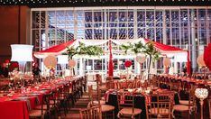 a banquet hall set up with red and white linens, gold chairs and tables