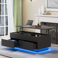 a living room with a laptop on top of a coffee table and drawers underneath it