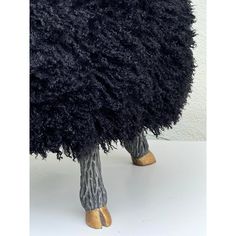 the legs and feet of a stuffed animal are covered in black fluffy fur with gold shoes