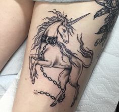 a woman's thigh with a tattoo of a unicorn on it