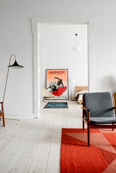 a living room filled with furniture and a painting hanging on the wall above an open door