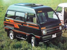 an old van is parked in the grass next to another van with its door open