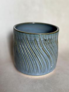 a close up of a blue cup on a white surface with lines drawn across it