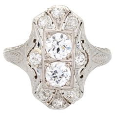 Elegant & finely detailed Belais Art Deco era ring (circa 1920s to 1930s) crafted in 14k white gold. Two centrally mounted old European cut diamonds are estimated at 0.48 carats each. A further 8 old mine cut diamonds total an estimated 0.42 carats. The total diamond weight is estimated at 1.38 carats (I-J color and VS2-I2 clarity). Belais Brothers is a highly regarded and very collectible maker from the late 19th century to the early 20th century. The ring epitomizes vintage charm and would mak Art Deco Diamond White Gemstone Jewelry, Art Deco Platinum Jewelry In Diamond White, Collectible Art Deco White Gold Jewelry, White Brilliant Cut Art Deco Jewelry, White Art Deco Collectible Ring, Art Deco Diamond Rings, Right Hand Rings, Alternative Engagement Rings, Art Deco Era