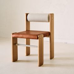 a chair made out of wood and rope with a leather seat pad on the back