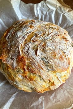 a round loaf of bread sitting on top of a piece of wax paper