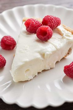 Raspberries top the 3-ingredient no bake cheesecake on a fluted plate.