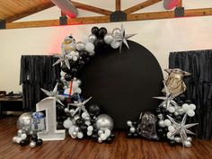 star wars themed balloon arch with black and white balloons, silver stars, and r2d2 decorations